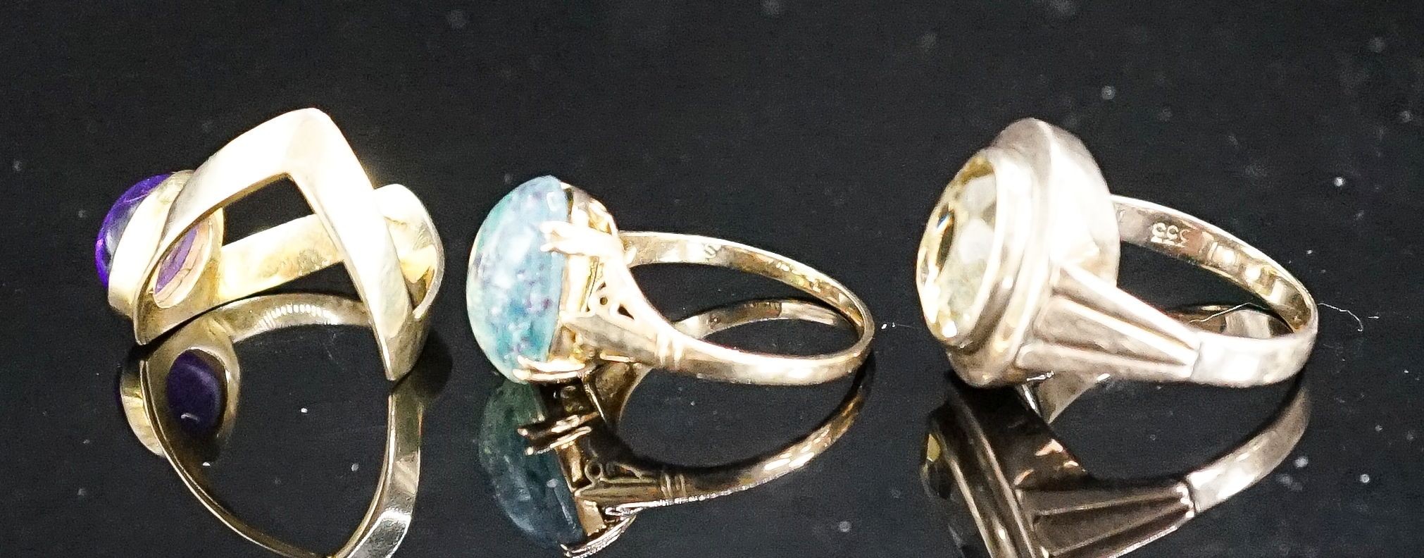 Two 9ct and gem set dress rings, gross 6.8 grams and a 333(8ct) and gem set dress ring, gross 5.6 grams.